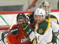The University of Calgary Dinos' Jadon Joseph battles the University of Alberta Golden Bears' Wyatt McLeod during Game 1 of the one of the Canada West championships at Father David Bauer Arena in Calgary on March 3, 2023.