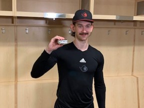 Ottawa Senators defenceman Jake Sanderson poses with the puck that went in the net for his first NHL goal on Nov. 23, 2022 in Las Vegas, Nev.
