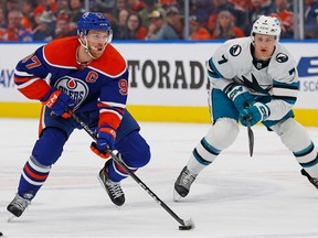 Edmonton Oilers forward Connor McDavid (97) looks to make a play in front of San Jose Sharks forward Nico Strum (7) during the first period at Rogers Place on March 20, 2023.