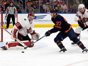The Edmonton Oilers' Connor McDavid (97) battles the Ottawa Senators' goalie Mads Sogaard (40) and Travis Hamonic (23) during first period NHL action at Rogers Place in Edmonton, Tuesday March 14, 2023.