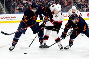 The Edmonton Oilers' Vincent Desharnais (73) and Derek Ryan (10) battle the Ottawa Senators' Brady Tkachuk (7) during second period NHL action at Rogers Place in Edmonton, Tuesday March 14, 2023.