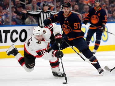 The Ottawa Senators' Austin Watson (16) battles the  Edmonton Oilers' Connor McDavid (97) during third period NHL action at Rogers Place in Edmonton, Tuesday March 14, 2023. The Oilers won 6-3.