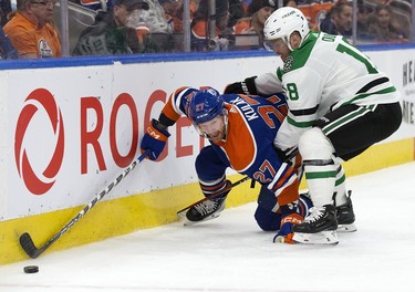 The Edmonton Oilers' Brett Kulak (27) battles the Dallas Stars' Max Domi (18) during second period NHL action at Rogers Place in Edmonton, Thursday March 16, 2023.