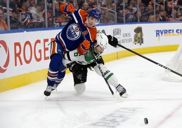 The Edmonton Oilers' Ryan Nugent-Hopkins (93) battles the Dallas Stars' Colin Miller (6) during third period NHL action at Rogers Place in Edmonton, Thursday March 16, 2023. The Oilers won 4-1.