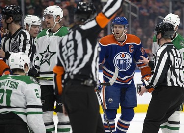The Edmonton Oilers' Connor McDavid (97) has words with the Dallas Stars' Jason Robertson (21) after a knee on knee collision during second period NHL action at Rogers Place in Edmonton, Thursday March 16, 2023. Robertson received a tripping penalty on the play.