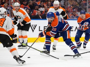 Leon Draisaitl (29) of the Edmonton Oilers battles the Philadelphia Flyers' Nick Seeler (24) during first period NHL action at Rogers Place in Edmonton on Feb. 21, 2023.