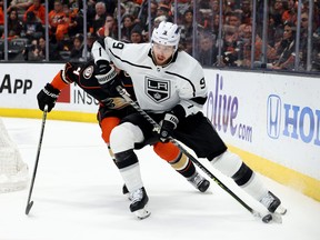 Adrian Kempe of the Los Angeles Kings looks to make a play with the puck as he is chased by Cam Fowler of the Anaheim Ducks during the third period in a 5-3 Kings win at Honda Center on April 13, 2023 in Anaheim, California.