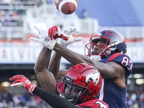 Montreal Alouettes reciever Eugene Lewis, right, leaps for a ball against the Calgary Stampeders in this file photo from Oct. 5, 2019.
