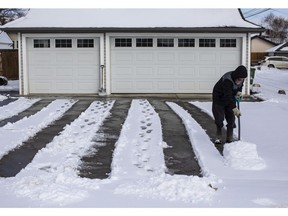 Rob Lothamer shovels snow off his driveway after snow fell overnight on March 26, 2022.