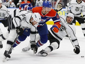 Apr 25, 2023; Edmonton, Alberta, CAN;Los Angeles Kings defensemen Vladislav Gavrikov and defensemen Matt Roy brings down Edmonton Oilers forward Connor McDavid during the third period in game five of the first round of the 2023 Stanley Cup Playoffs at Rogers Place.