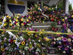 Bouquets of flowers pile up at the memorial outside of the Old National Bank for the victims of a mass shooting in Louisville, Ky., April 14, 2023.