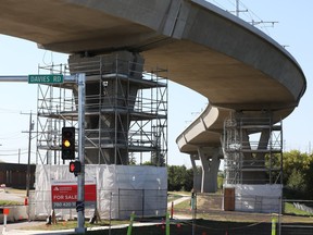 concrete structures holding up a section of Valley Line LRT tracks are surrounded by scaffolding as they undergo repairs