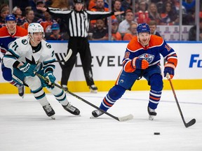Edmonton Oilers Zach Hyman (18) skates for the puck past San Jose Sharks Nikolai Knyzhov (71) during first period NHL action on Thursday, April 13, 2023 in Edmonton.
