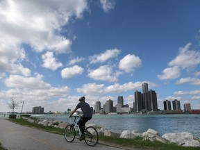 FILE - A cyclist is shown along the Detroit river in Windsor, Ontario as the Detroit, Michigan skyline is shown in the background on Wednesday, October 13, 2021.