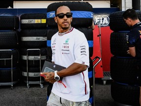 Mercedes driver Lewis Hamilton walks in the pit lane ahead of the Monaco Formula 1 Grand Prix.