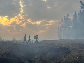 Firefighters return to retrieve more gear while tackling the Deep Creek Wildfire Complex near Entwistle, Alberta, on May 15, 2023.
