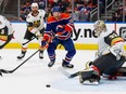 Oilers forward Zach Hyman (18) chases a loose puck in front of Vegas Golden Knights goaltender Adin Hill (33) during the third period in game three of the second round of the 2023 Stanley Cup Playoffs at Rogers Place.