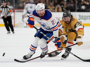 Edmonton Oilers defenseman Brett Kulak (27) and Vegas Golden Knights defenseman Dysin Mayo (61) vie for the puck during the first period of Game 1 of an NHL hockey Stanley Cup second-round playoff series Wednesday, May 3, 2023, in Las Vegas.