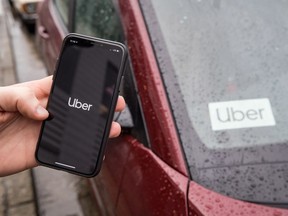 The Uber app is seen on an iPhone near a driver's vehicle after the company launched service, in Vancouver, Friday, Jan. 24, 2020.