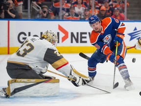 Kailer Yamamoto of the Edmonton Oilers, in front of goalie Adin Hill of the Las Vegas Golden Knights