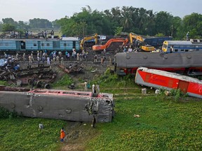 Policemen inspect the wrecked carriages of a three-train collision near Balasore, in India's eastern state of Odisha, on June 4, 2023. Authorities were scrambling on June 4 to understand the cause of a three-train collision in India that killed at least 288 people, claiming that "no one responsible" will be spared.