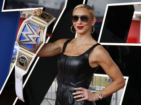 WWE Superstar Charlotte Flair shows off her championship wrestling belt as she poses for photographers during a red carpet event before the start of the NASCAR Daytona 500 auto race at Daytona International Speedway, Sunday, Feb. 19, 2023, in Daytona Beach, Fla.