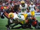 Edmonton Elks wide receiver Eugene Lewis (87) is tackled by B.C. Lions defensive back T.J. Lee (6), with help from linebacker Boseko Lokombo (20) and defensive back Jalon Edwards-Cooper (29) in Vancouver on Saturday, June 17, 2023.
