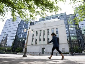 A woman walks past the Bank of Canada headquarters, Wednesday, June 1, 2022 in Ottawa.