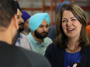 Alberta Premier Danielle Smith smiles as she talks to supporters.