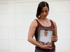 Carmen Claydon holds a photo of her husband, Const. Trevor Claydon, outside her home on June 9, 2023. Claydon died by suicide in June 2020.