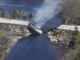 The collapsed bridge between the Clyde River and Port Clyde in Nova Scotia smoulders in this Wednesday, May 31, 2023 handout photo. As an unprecedented string of wildfires in Nova Scotia continued to burn out of control Wednesday, thousands of residents forced to flee their homes spent a fourth day wondering what their neighbourhoods will look like when they return home.THE CANADIAN PRESS/HO-Communications Nova Scotia **MANDATORY CREDIT**