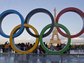 FILE - The Olympic rings are set up in Paris, France, Thursday, Sept. 14, 2017 at Trocadero plaza that overlooks the Eiffel Tower, a day after the official announcement that the 2024 Summer Olympic Games will be in the French capital. French investigators searched the headquarters of Paris Olympic organizers on Tuesday in a probe into suspected corruption, according to the national financial prosecutor's office.