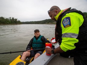 Park ranger Zain Haji does a safety compliance check makings sure that the kayaker has all of the safety equipment on board as representatives from City of Edmonton Park Rangers, Edmonton Fire Rescue Services and Edmonton Police Service, talk about another busy summer of recreation on the North Saskatchewan River and are reminding people about the regulations that ensure everyone enjoys a safe summer season.on Thursday, June 1, 2023 in Edmonton. Greg Southam-Postmedia