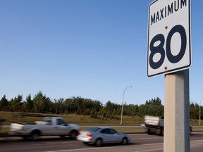 An 80 km/h speed limit sigh on Whitemud Freeway as vehicles drive on the road in the background