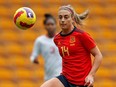 Spanish midfielder Alexia Putellas chips the ball past Canadian midfielder Jessie Fleming during a match.