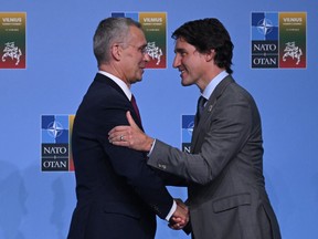 NATO Secretary-General Jens Stoltenberg, left, greets Prime Minister Justin Trudeau at the NATO Summit in Vilnius on Tuesday, July 11, 2023.