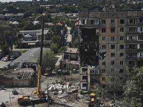 Emergency services work at a scene after a missile hit an apartment building in Kryvyi Rih, Ukraine, Monday, July 31, 2023.