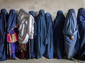 Afghan women wait to receive food rations distributed by a humanitarian aid group, in Kabul, Afghanistan, Tuesday, May 23, 2023. In a report issued on Monday, July 17, 2023, the U.N. says Taliban authorities have further increased restrictions on the rights of women and girls in Afghanistan in recent months.