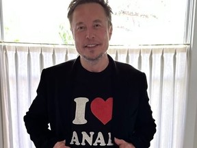 Elon Musk partially covers his 'I ♥ Canada' shirt.
