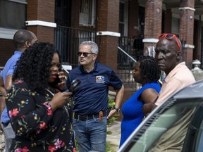 District Attorney Larry Krasner and other officials are walk through the neighborhood after last night's mass shooting in Philadelphia, on Tuesday, July 4, 2023. Police say a gunman in a bulletproof vest has opened fire on the streets of Philadelphia Monday night, killing several people and wounding two boys before he surrendered to responding officers.