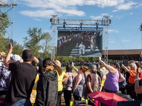 People watch a large screen as Pope Francis makes his way to the lake on Tuesday, July 26, 2022 at Lac Ste. Anne. The 2023 pilgrimage was cancelled after extreme weather Monday. Greg Southam/Postmedia