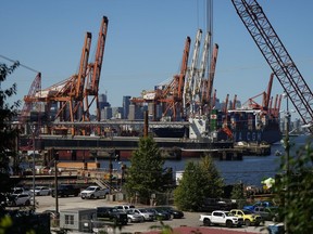 Gantry cranes sit idle as a container ship is docked at port during a work stoppage, in Vancouver, on Wednesday, July 19, 2023.