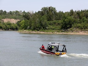 Members of Edmonton Fire Rescue work near Dawson Park after responding to a call about a person in the North Saskatchewan River on Monday June 5, 2023.