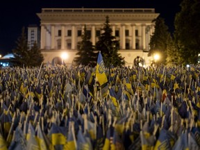 Flags honouring Ukrainian troops killed in the country's war against Russia are lit by street lights during a nightly curfew imposed at midnight, in Kyiv, Ukraine, Monday, July 10, 2023.