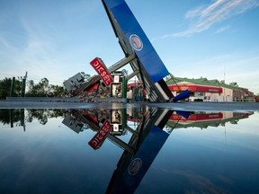 A storm-damaged gas station is reflected in a puddle after Hurricane Idalia crossed the state on August 30, 2023 in Perry, Florida.