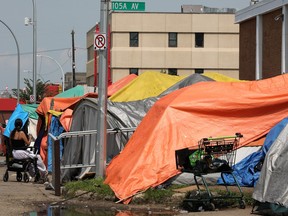 Makeshift tents line a street in an industrial-looking area