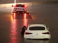 A tow truck driver attempts to pull a stranded car out of floodwaters on the Golden State Freeway as tropical storm Hilary moves through the area on August 20, 2023 in Sun Valley, California.
