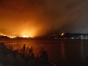 The McDougall Creek wildfire burns in the hills West Kelowna, B.C., on Aug. 17, as seen from Kelowna.