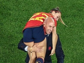 This picture taken on August 20, 2023 shows President of the Royal Spanish Football Federation Luis Rubiales carrying Spain's Athenea del Castillo Beivide on his shoulder as they celebrate winning the Australia and New Zealand 2023 Women's World Cup final football match between Spain and England at Stadium Australia in Sydney.