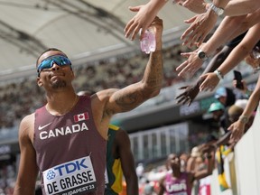 Andre De Grasse, of Canada, receives high fives from fans during the men's 200-metre heat at the World Athletics Championships in Budapest, Hungary, Wednesday, Aug. 23, 2023.